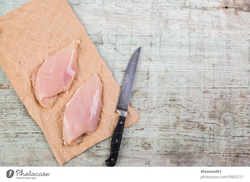 Chicken breast on brown paper and a knife overhead view from above top view Overhead Overhead Shot View From Above sliced raw nobody studio shot studio shots