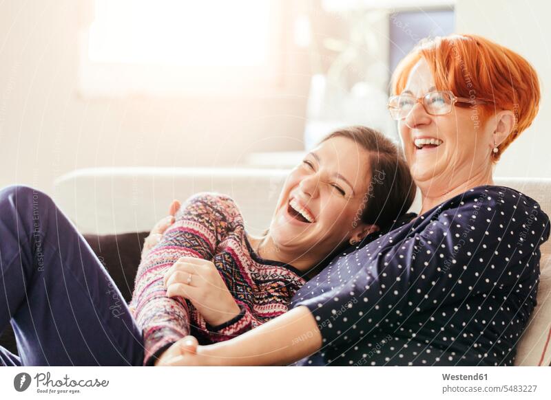 Happy adult daughter with mother at home mommy mothers ma mummy mama laughing Laughter happiness happy daughters woman females women parents family families