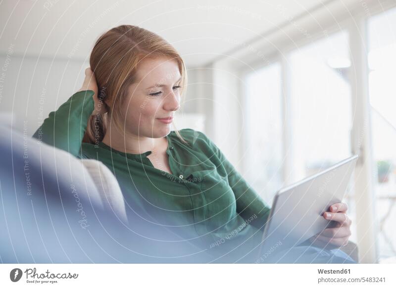 Portrait of smiling young woman with digital tablet relaxing on the couch smile relaxation relaxed leaning rested on wireless Wireless Connection