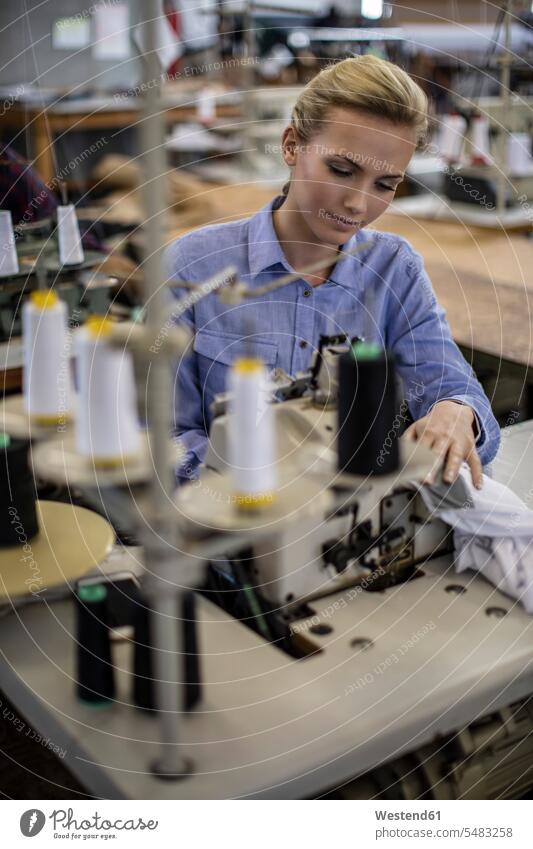 Seamstress working on sewing machine tailoring dressmaking woman females women seamstress seamstresses sewing machines tailor shop Adults grown-ups grownups