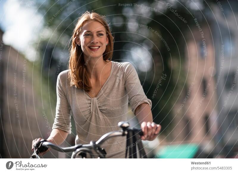 Portrait of redheaded woman with bicycle portrait portraits females women bikes bicycles Adults grown-ups grownups adult people persons human being humans