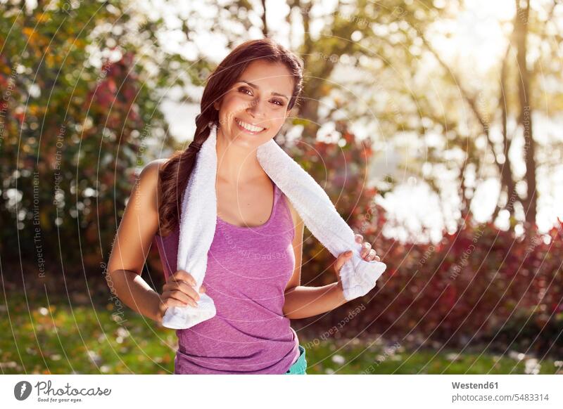 Portrait of smiling female athlete with towel outdoors smile sportswoman athletes sportswomen female athletes females sportive sporting sporty athletic