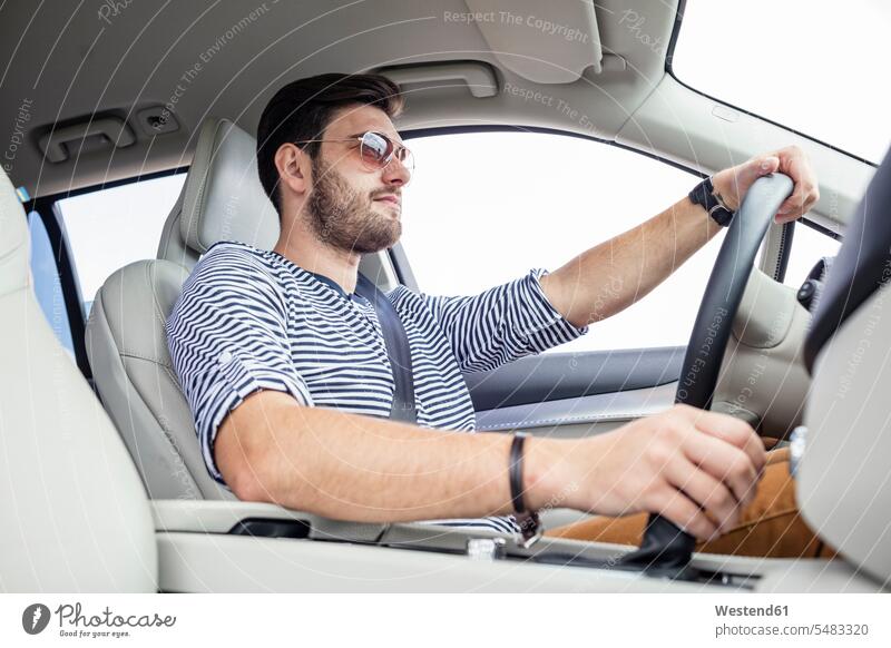Mid adult man driving in car drive automobile Auto cars motorcars Automobiles car driving motoring Road Trip roadtrip Road-Trip belted fastened steering wheel