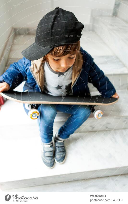 Boy sitting on stairs holding skateboard caucasian caucasian ethnicity caucasian appearance european staircase staircases stairwell one person 1 one person only