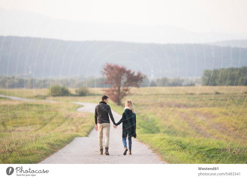 Young couple walking in rural landscape going nature natural world twosomes partnership couples people persons human being humans human beings Solitude