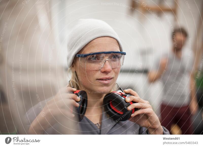 Woman wearing safety goggles and earmuffs in workshop working At Work craft crafts handwork handcraft hand work manual labour manual work handicraft woman
