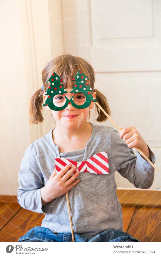 Portrait of smiling little girl with Christmas tree spectacles and toy bow disguise dressed up masquerade dressing up dress up masquerades disguised dress-up