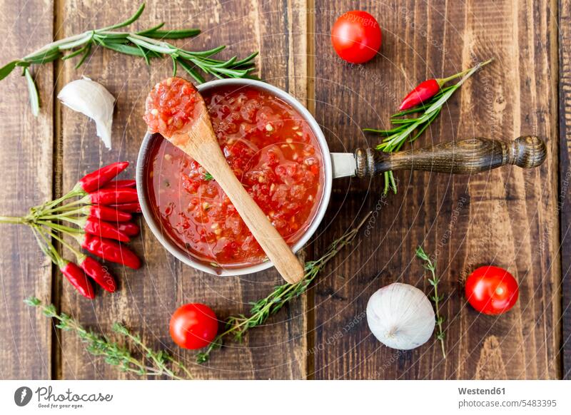 Saucepan of homemade tomato sauce and ingredients on wood overhead view from above top view Overhead Overhead Shot View From Above wooden spice flavouring