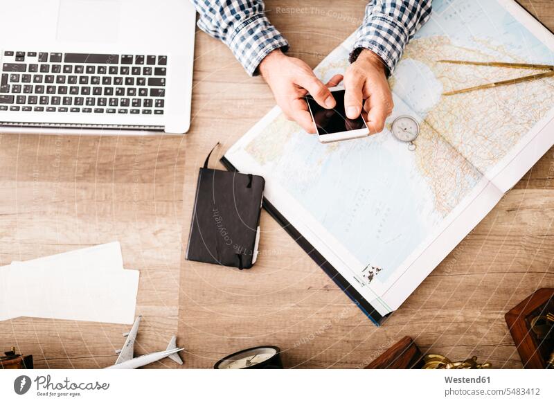 Man sitting at his desk planning his next journey Travel young man young men compass compasses navigational compass Planning planned Atlas males Adults