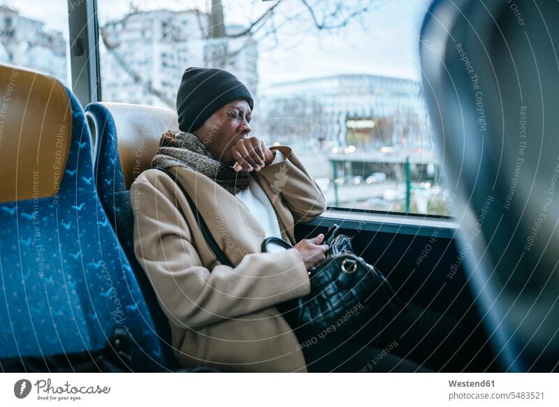 Yawning young woman traveling by bus busses females women motor vehicle road vehicle road vehicles motor vehicles transportation Adults grown-ups grownups adult