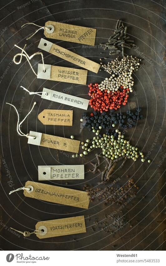 Various sorts of pepper and labelled tags Xylopia aethiopica dark background selection Assortment Brown Background brown western script pink peppercorn name
