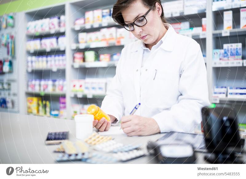 Pharmacist with medicine at counter in pharmacy counters pharmacist chemists Apothecary drugstores pharmacies medication Medicines medicament