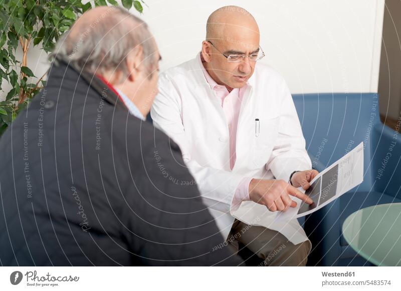 Doctor talking about the medical evidence with patient discussing discussion occupation profession professional occupation jobs people persons human being