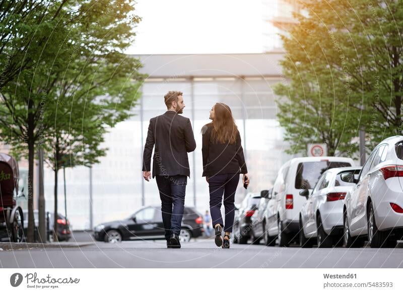 Businessman and businesswoman walking outdoors going businesswomen business woman business women Business man Businessmen Business men business people