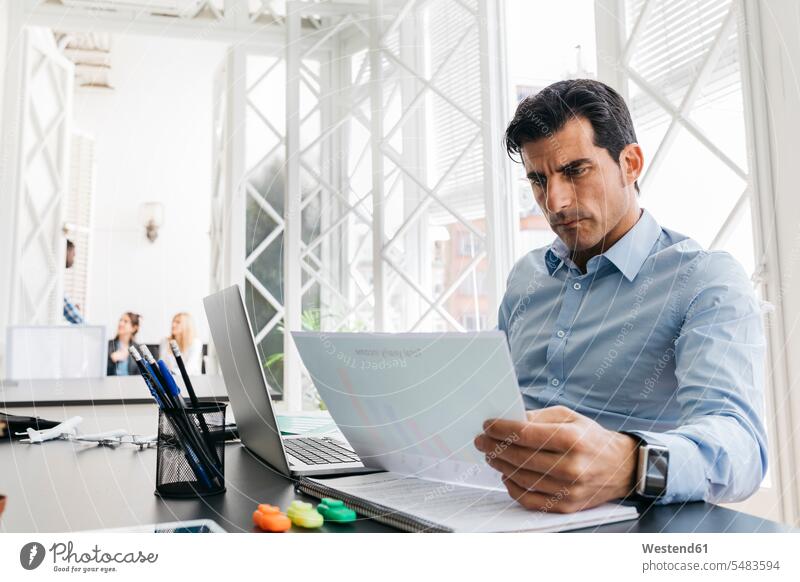 Businessman working in office, reading papers Small Business Business man Businessmen Business men sitting Seated desk desks accessibility accessible online