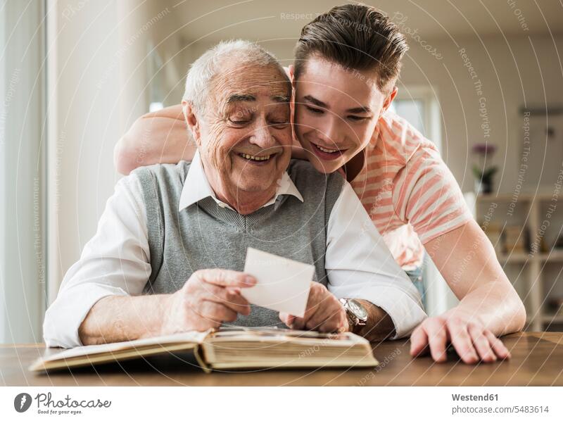 Grandfather and grandson watching old photographies together leisure activity leisure activities familiarity Trust Confidence Faith portrait portraits old man