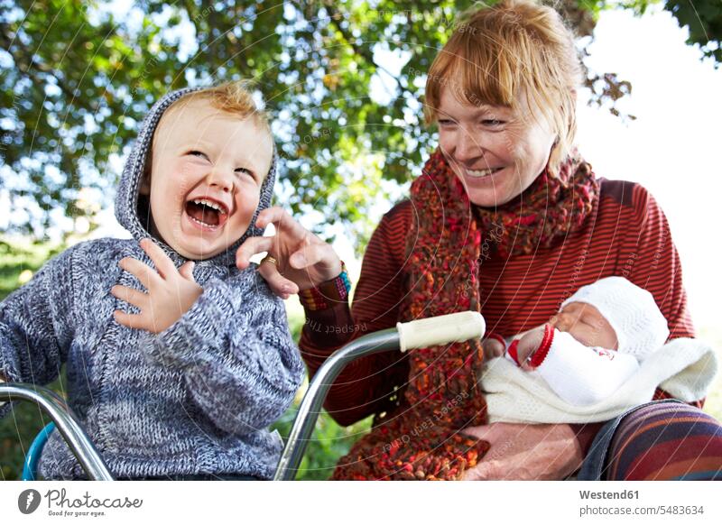 Happy mother with son and baby in the nature laughing Laughter mommy mothers ma mummy mama Fun having fun funny child children family families babies infants