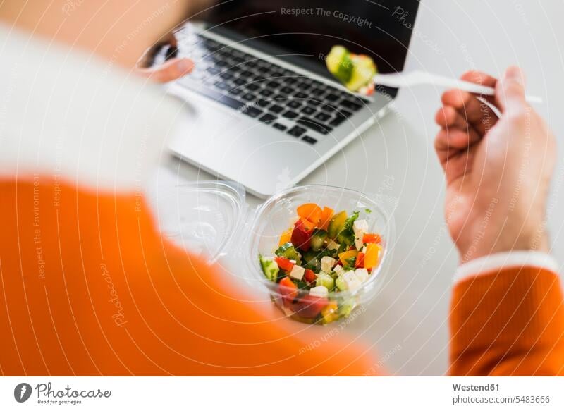 Young man having a salad at desk in office occupation profession professional occupation jobs convenience amenities convenient amenity comfort healthy eating
