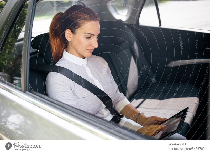 Businesswoman sitting on backseat of a car using tablet digitizer Tablet Computer Tablet PC Tablet Computers iPad Digital Tablet digital tablets businesswoman