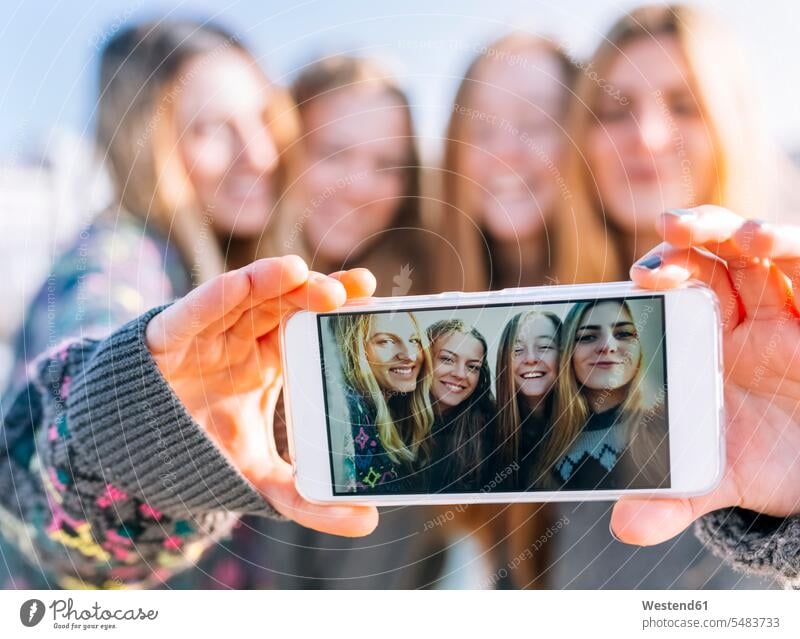 Group picture of four friends on display of smartphone, close-up mate female friend Selfies photograph Device Screen Device Screens Display Screen