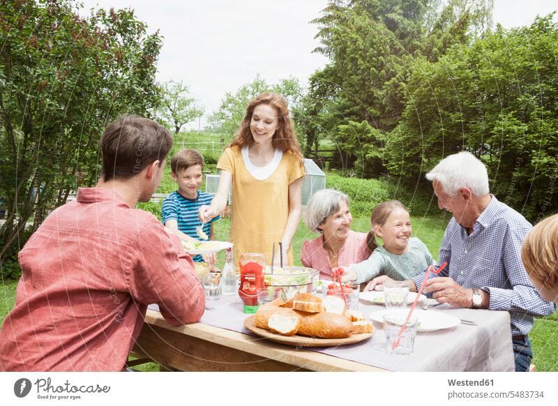Happy extended family dining in garden gardens domestic garden generations happiness happy families eating people persons human being humans human beings casual