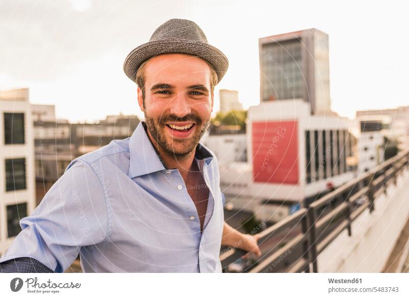Portrait of happy young man on rooftop roof terrace deck men males portrait portraits smiling smile Adults grown-ups grownups adult people persons human being