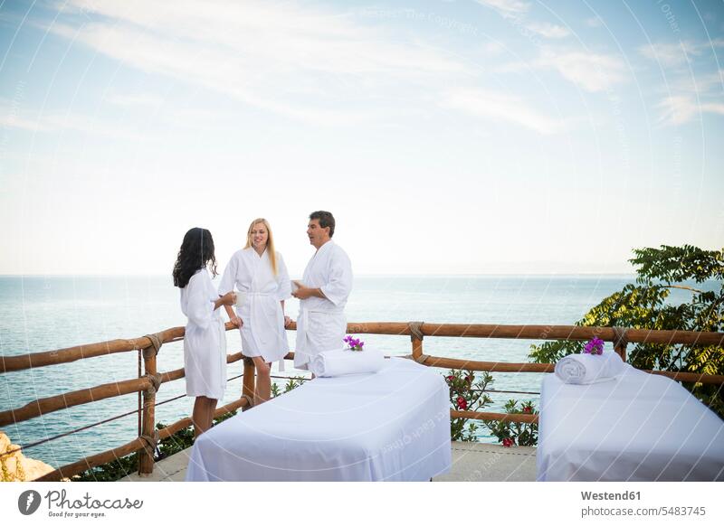 Vacation guests waiting for their outdoor massage on ocean front terrace of a luxury vacation resort bathrobe bath robes bathrobes wellness wellbeing holidays