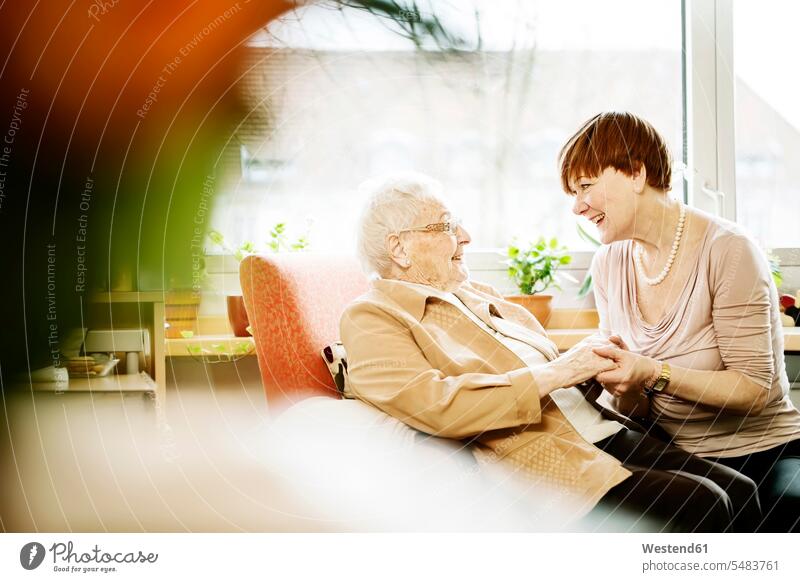 Adult daughter talking to her mother with Alzheimer's disease in her room at retirement home adult daughter adult daughtes assistance Looking After support care