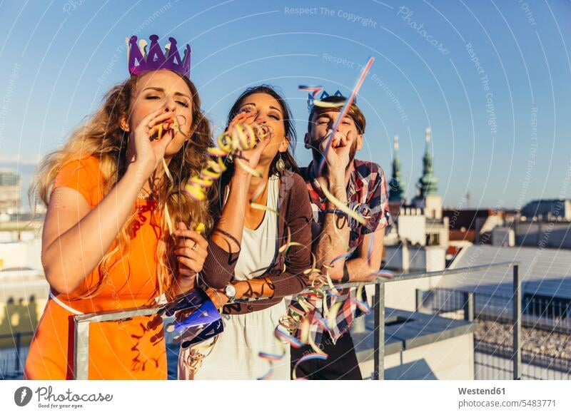 Austria, Vienna, Young people having a party on rooftop terrace friendship carefree leaning rested on Railing Railings roof terrace deck fancy chic