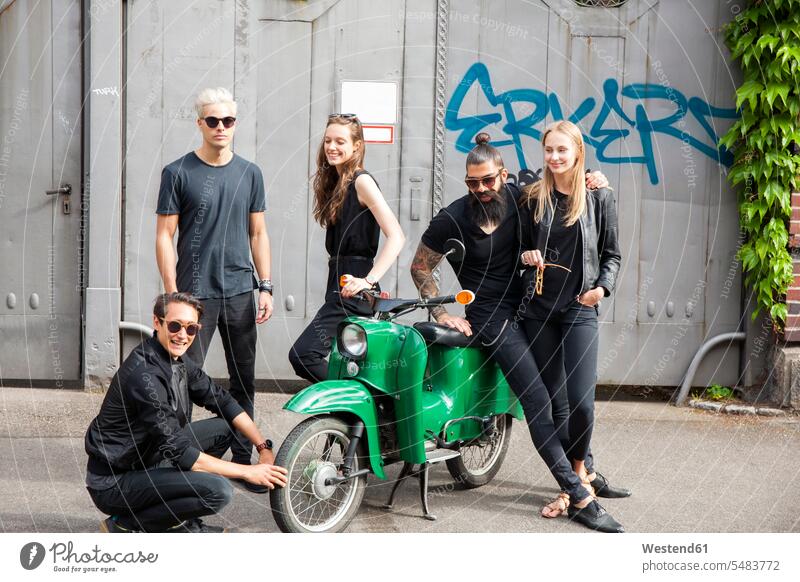 Group of five black dressed friends with green moped 20-25 years 20 to 25 20 to 25 years young women young woman young man young men mid adult men mid adult man