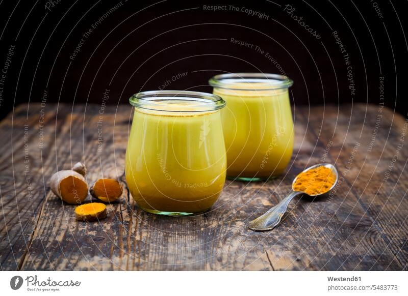 Two glasses of curcuma milk Glass Glasses healthy eating nutrition lifestyle life styles wooden rustic turmeric homemade home made home-made tea spoon Teaspoon
