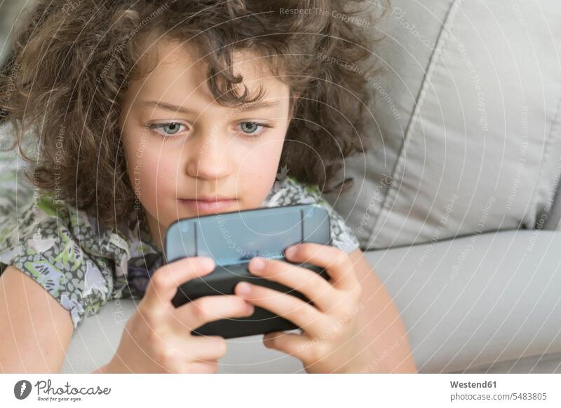Girl playing with mobile device mobile phone mobiles mobile phones Cellphone cell phone cell phones girl females girls child children kid kids people persons