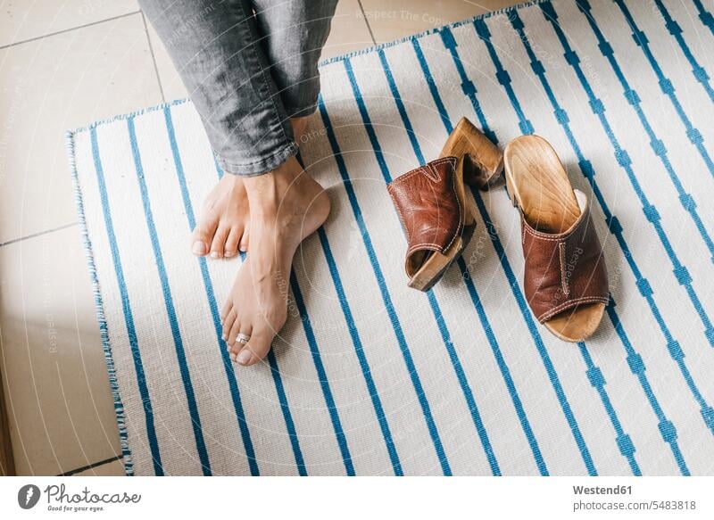 Barefoot feet of a woman beside her shoes resting human foot human feet people persons human being humans human beings recovering barefoot naked feet naked foot