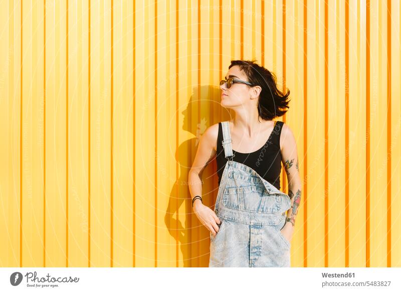 Young woman standing against a yellow wall caucasian caucasian ethnicity caucasian appearance european brown hair brown haired brown-haired brunette shadow
