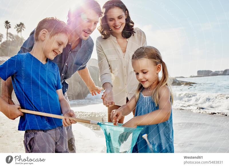 Happy family with dip net on the beach dip nets scoop nets landing net beaches families happiness happy smiling smile people persons human being humans
