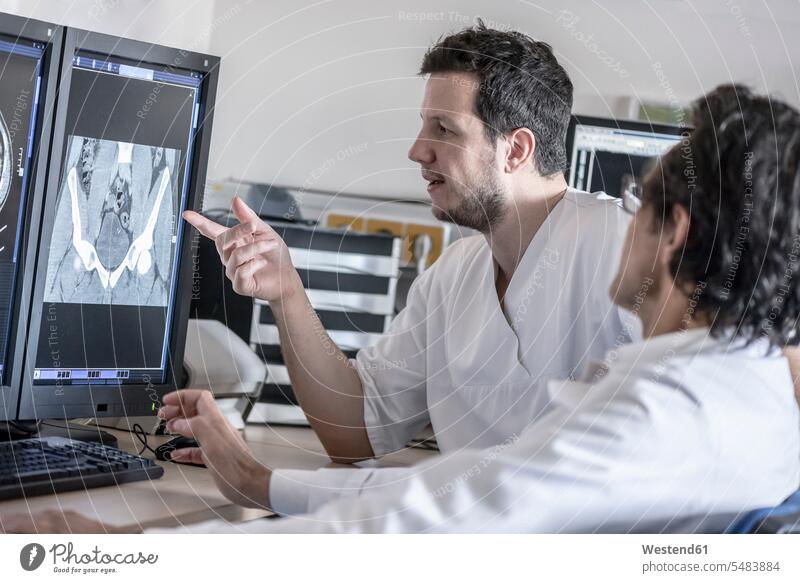 Two doctors discussing x-ray image on computer screen Medical X-Ray colleagues physicians discussion x-raying physical examination Medical Exam