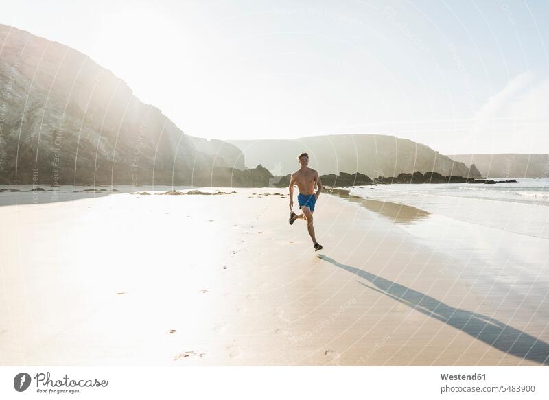 France, Crozon peninsula, young man running on the beach beaches men males Jogging jogger joggers Adults grown-ups grownups adult people persons human being