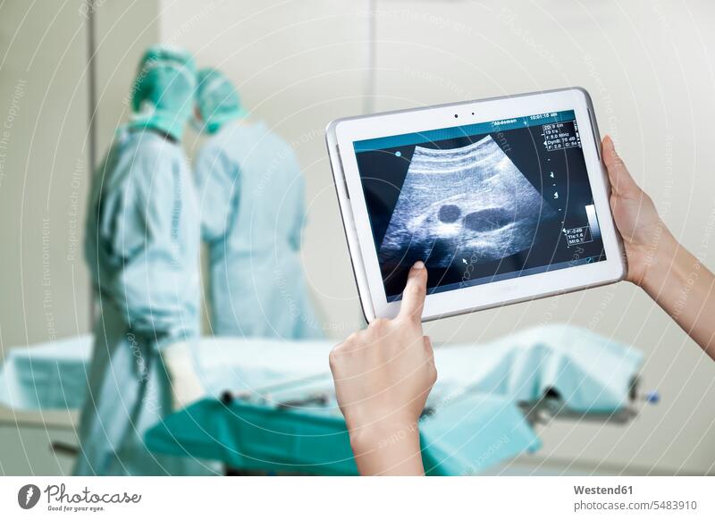 Hands holding digital tablet with ultrasound image in operating theatre digitizer Tablet Computer Tablet PC Tablet Computers iPad Digital Tablet digital tablets