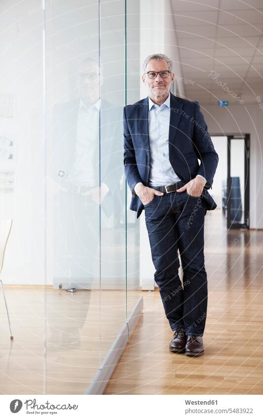 Successful businessman standing in his office with hands in pockets caucasian caucasian ethnicity caucasian appearance european Hands in pockets hand in pocket