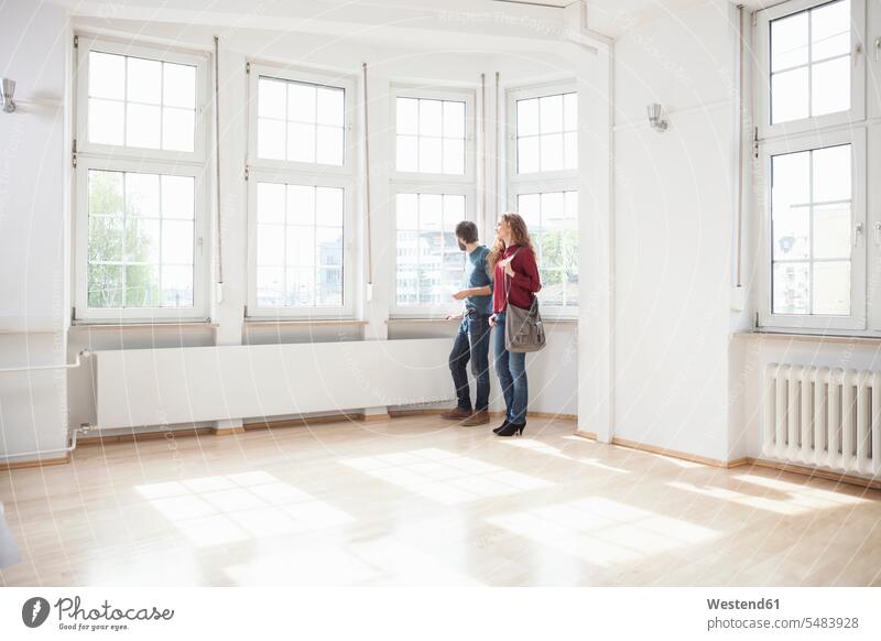 Couple looking around in empty apartment visiting viewing moving in move in flat flats apartments moving house Moving Home couple twosomes partnership couples