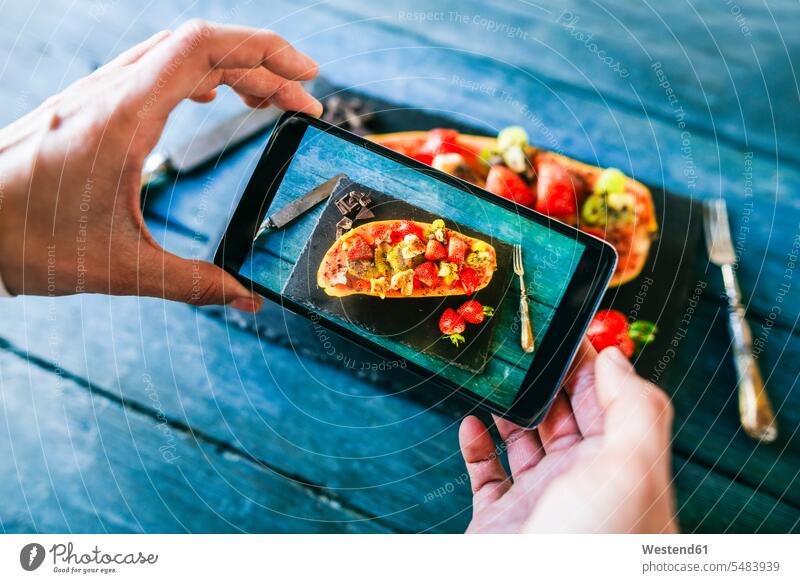 Close-up of woman's hands taking a photo with a varied of fruit served in a papaya photograph photographs photos Smartphone iPhone Smartphones mobile phone