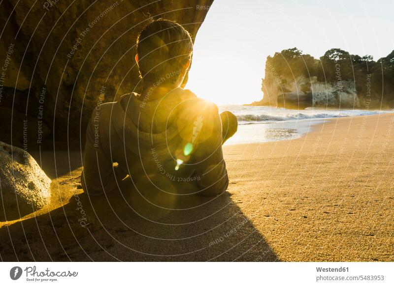 New Zealand, Wanganui, back view of man lying on the beach watching sunrise laying down lie lying down sun rise sunrises men males beaches atmosphere