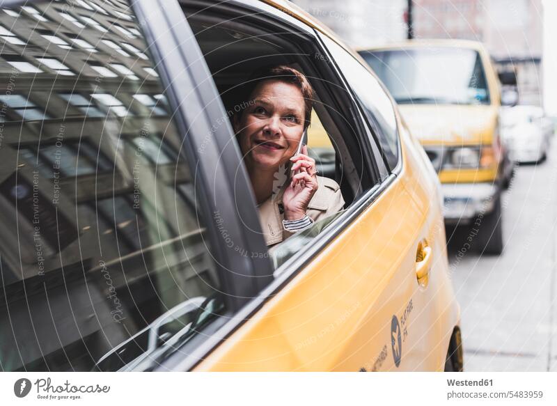 USA, New York City, smiling woman in taxi on cell phone smile mobile phone mobiles mobile phones Cellphone cell phones females women Taxies on the phone call