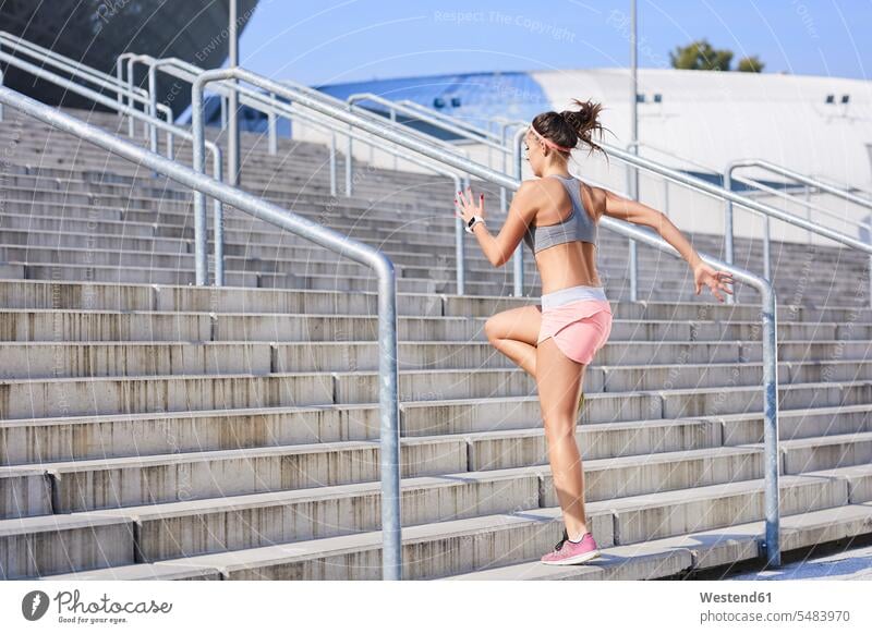 Fit young woman running on stairs fit stairway exercising exercise training practising females women Adults grown-ups grownups adult people persons human being