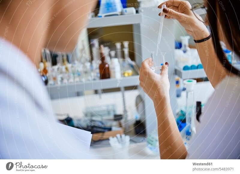 Young woman pipetting in laboratory pipette females women working At Work Adults grown-ups grownups adult people persons human being humans human beings
