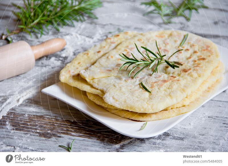Stack of naan breads with rosemary twig on plate food and drink Nutrition Alimentation Food and Drinks Plate dish dishes Plates platter platters close-up
