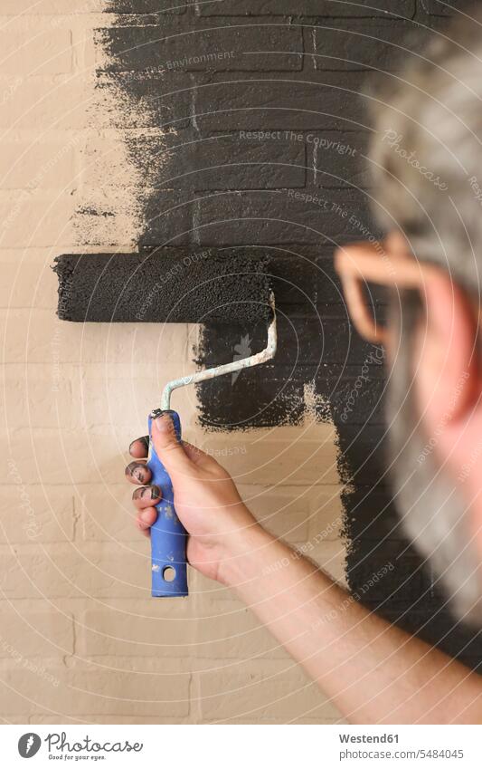 Man painting the wall black house painter hand human hand hands human hands handyman do-it-yourselfer paint roller craftsman trade craftsmen Craft Occupation