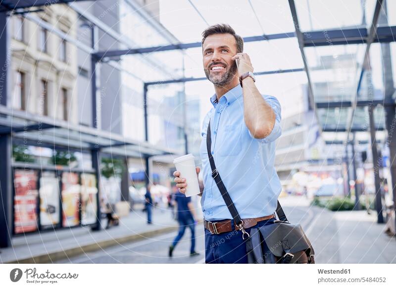 Businessman talking on phone and using public transport smiling smile men males Coffee mobile phone mobiles mobile phones Cellphone cell phone cell phones