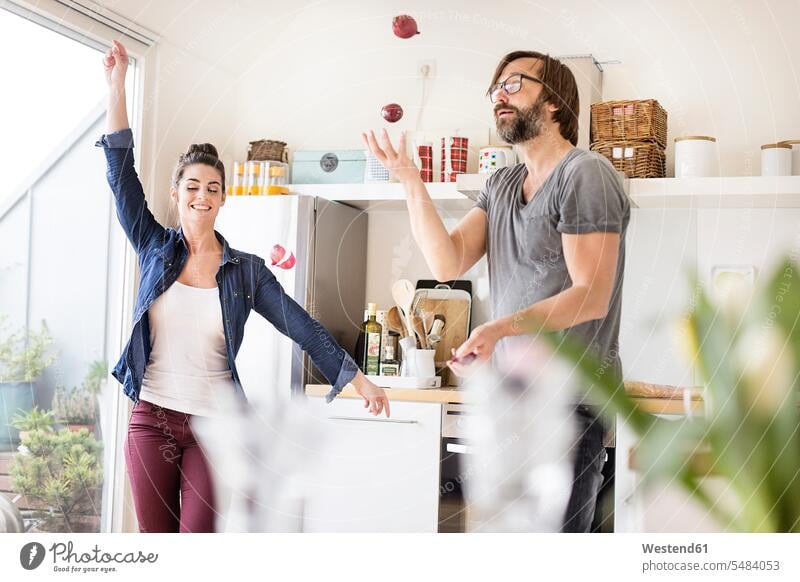 Playful couple in kitchen domestic kitchen kitchens twosomes partnership couples happiness happy people persons human being humans human beings Fun having fun