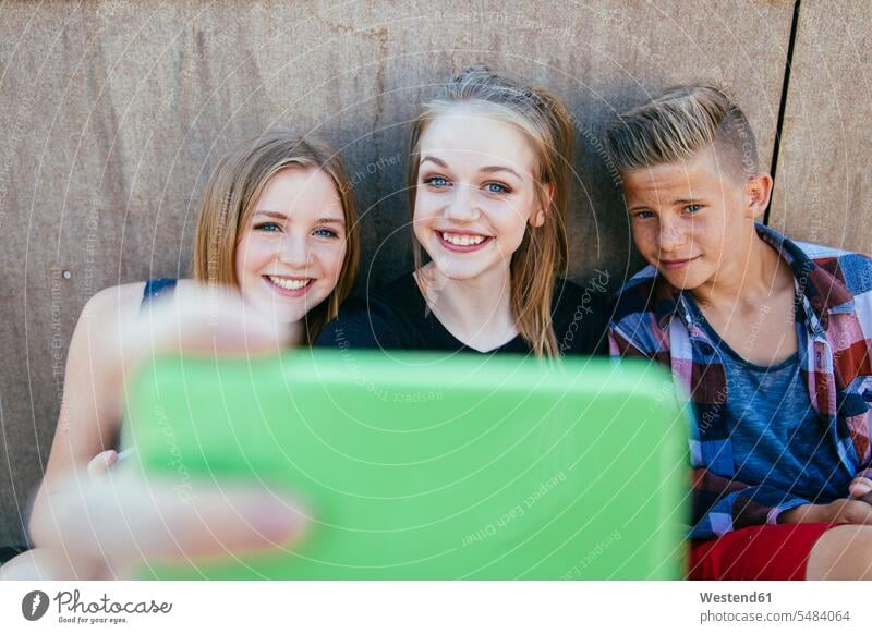 Three teenagers outdoors taking a selfie youth casual leisure wear casual clothing casual wear casual clothes Casual Attire Selfie Selfies Enjoyment Amusement